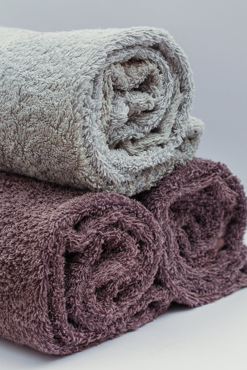 Close-up of rolled bathroom towels in neutral tones, ideal for interior design or spa themes.